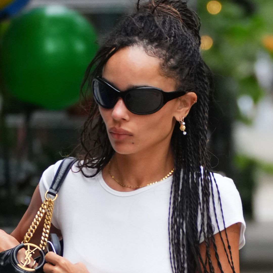 Zoë Kravitz носит черные балетки с джинсами и белой футболкой